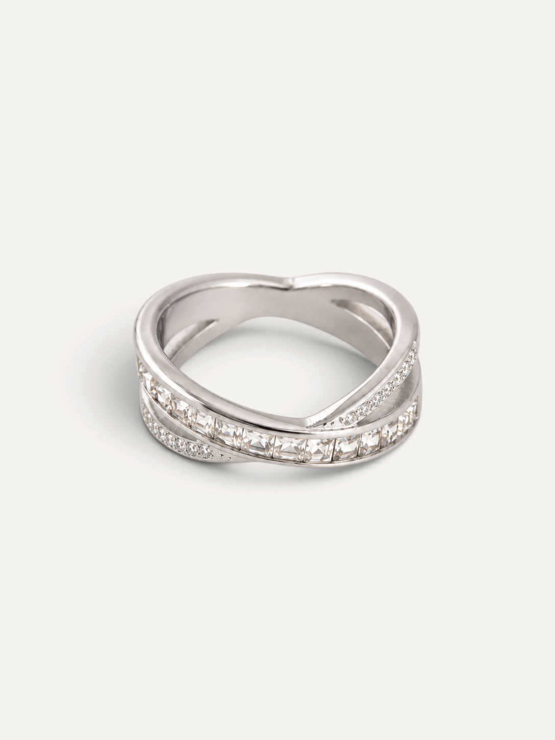 CÉLOIR NOVA Ring aus silberfarbenem Edelstahl mit gekreuztem Design und funkelnden Zirkonia-Steinen