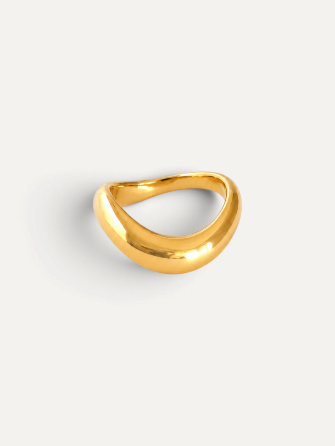 CÉLOIR Viona Ring aus goldfarbenem Edelstahl mit geschwungenem, organischem Design auf weißem Hintergrund