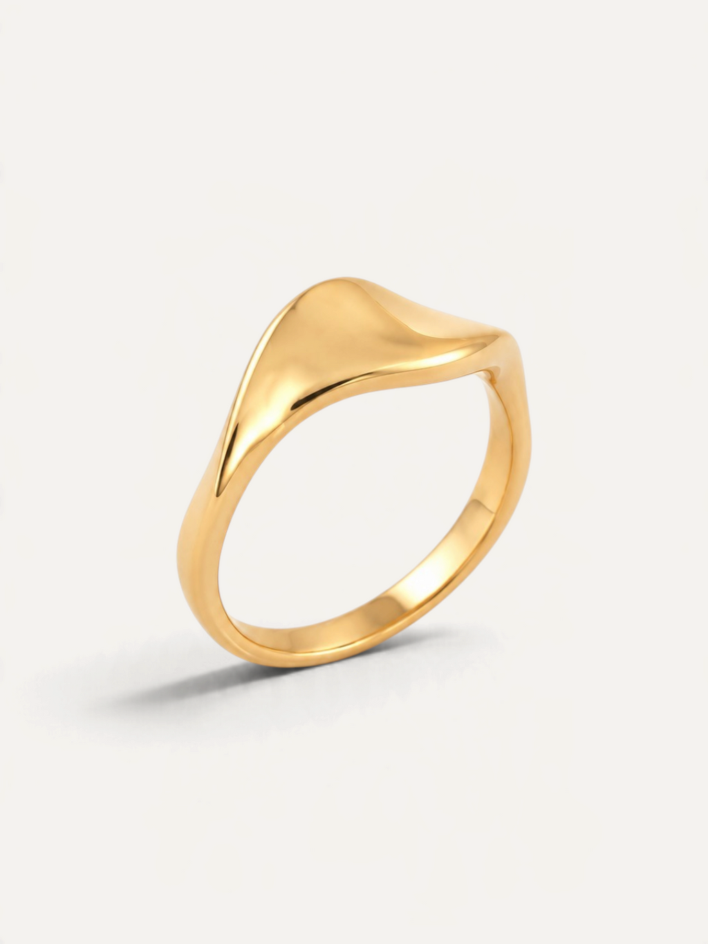 CÉLOIR ARENA Ring aus goldfarbenem Edelstahl mit geschwungenem, organischem Design auf weißem Hintergrund