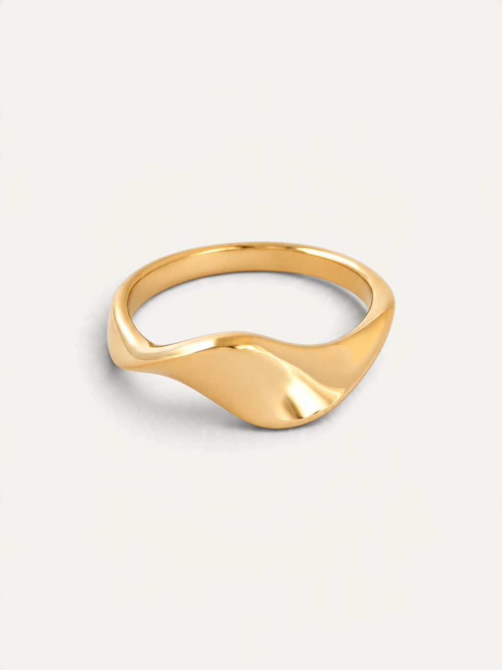 CÉLOIR ARENA Ring aus goldfarbenem Edelstahl mit geschwungenem, organischem Design auf weißem Hintergrund
