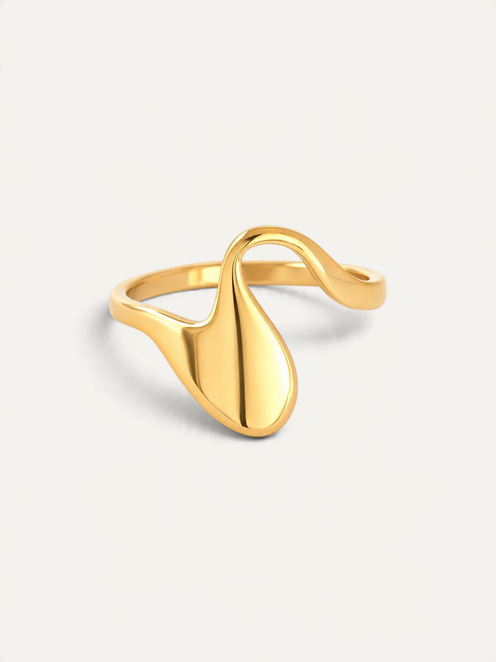 CÉLOIR Seda Ring aus goldfarbenem Edelstahl mit geschwungenem, organischem Design auf weißem Hintergrund