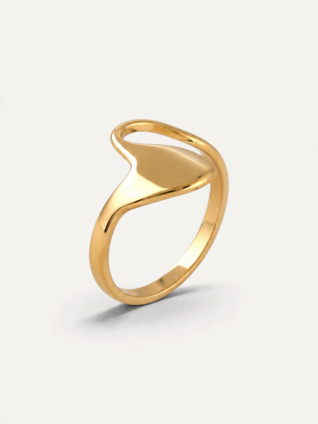 CÉLOIR Seda Ring aus goldfarbenem Edelstahl mit geschwungenem, modernem Design auf weißem Hintergrund