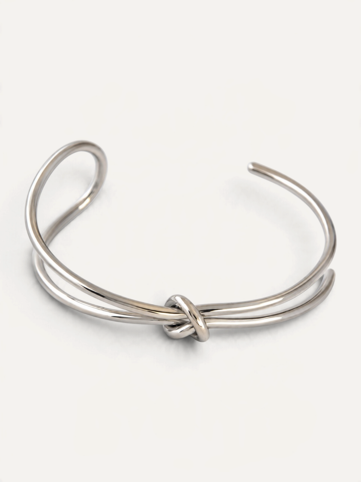 CÉLOIR TIED Armreif aus silberfarbenem Edelstahl mit elegantem Knotendetail in minimalistischem Design