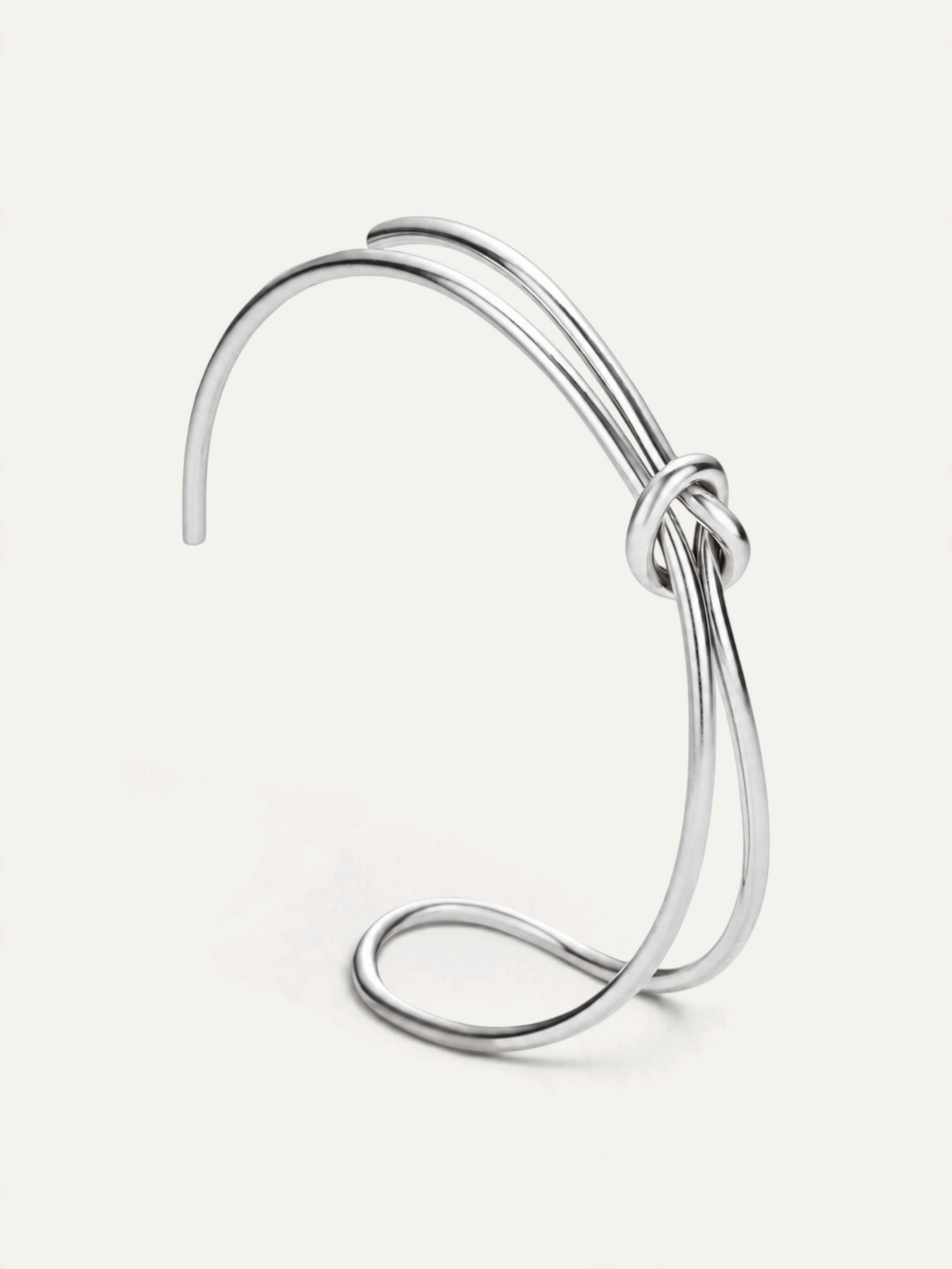 CÉLOIR TIED Armreif aus silberfarbenem Edelstahl mit elegantem Knotendesign in minimalistischer Optik
