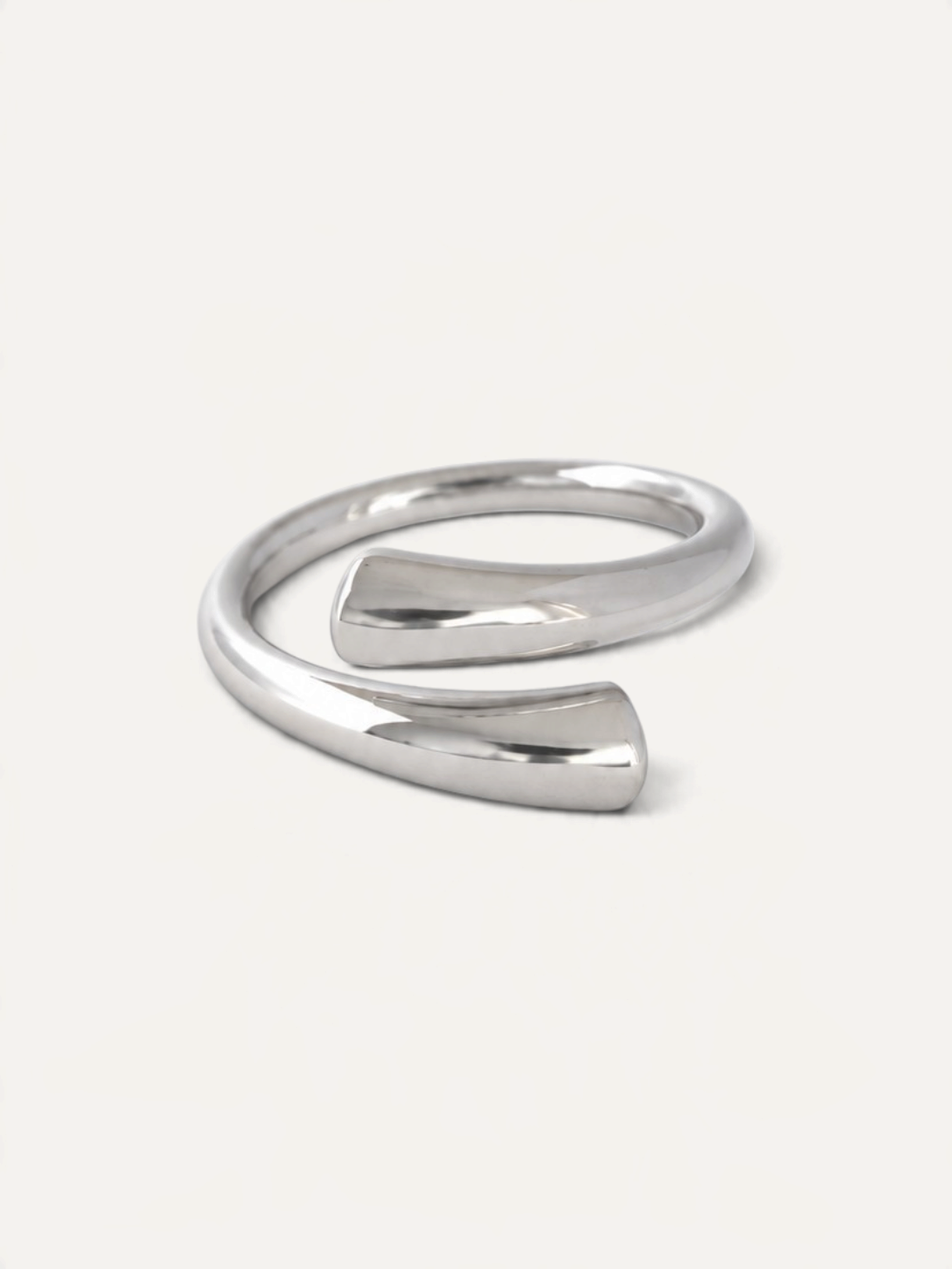 CÉLOIR TWIN Ring aus silberfarbenem Edelstahl in modernem, offenem Wickeldesign auf weißem Hintergrund