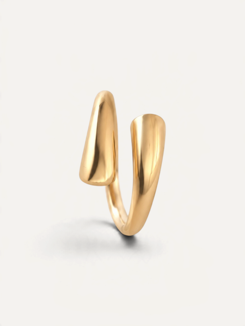 CÉLOIR Twin Ring aus goldfarbenem Edelstahl mit modernem, offenem Design auf weißem Hintergrund