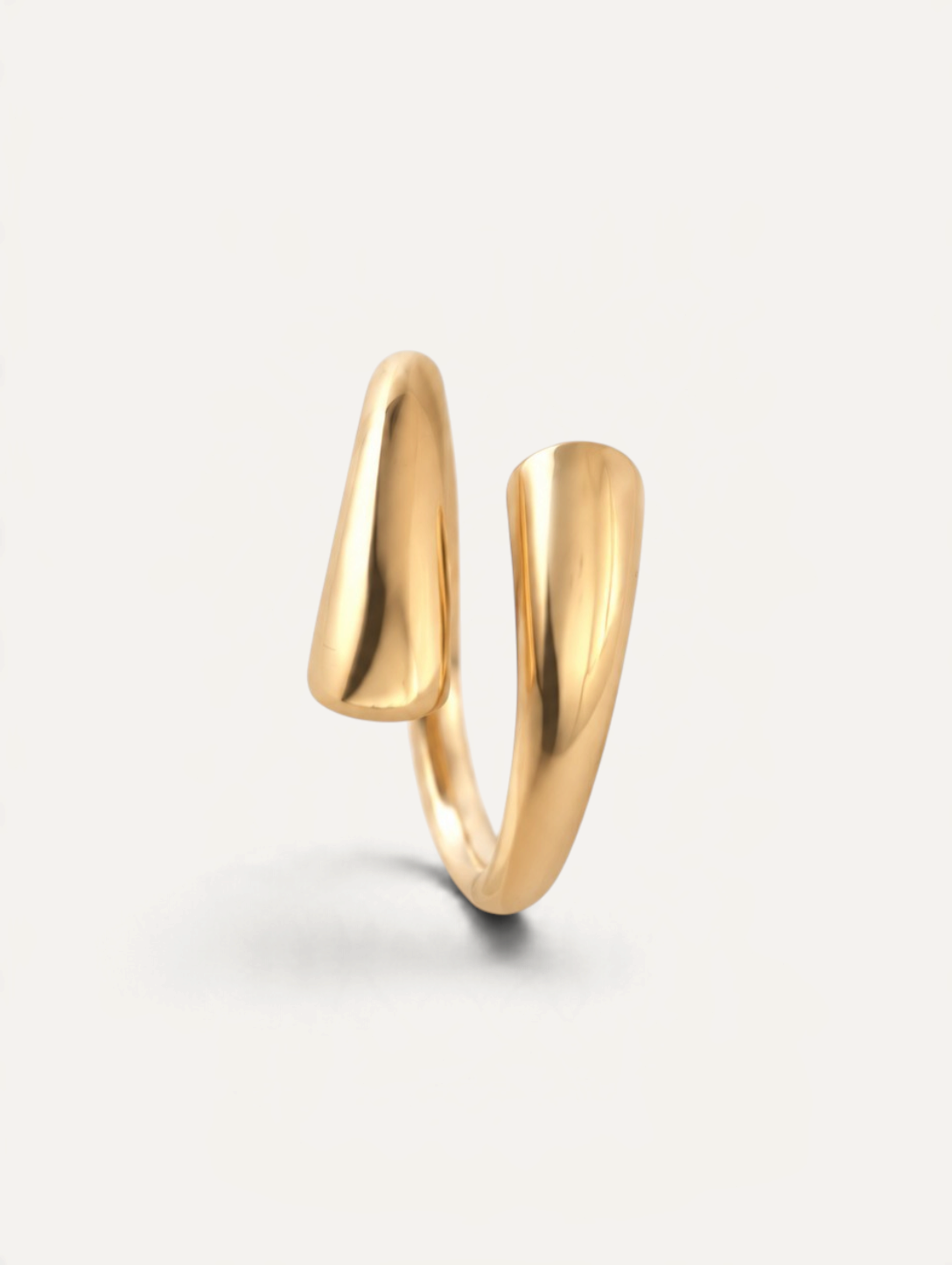 CÉLOIR Twin Ring aus goldfarbenem Edelstahl mit modernem, offenem Design auf weißem Hintergrund