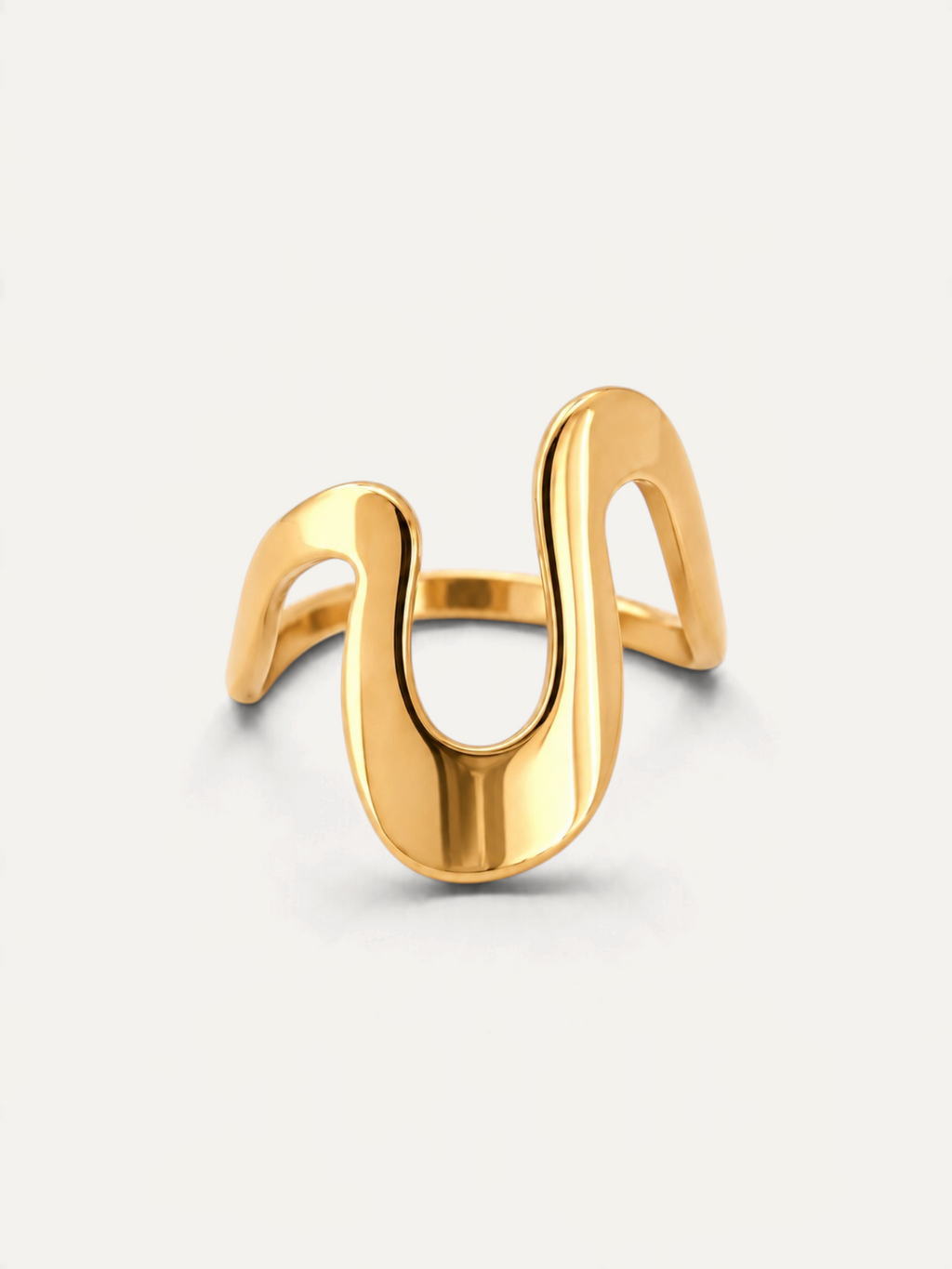 CÉLOIR Vantage Ring aus goldfarbenem Edelstahl mit geschwungenem, modernem Design auf weißem Hintergrund