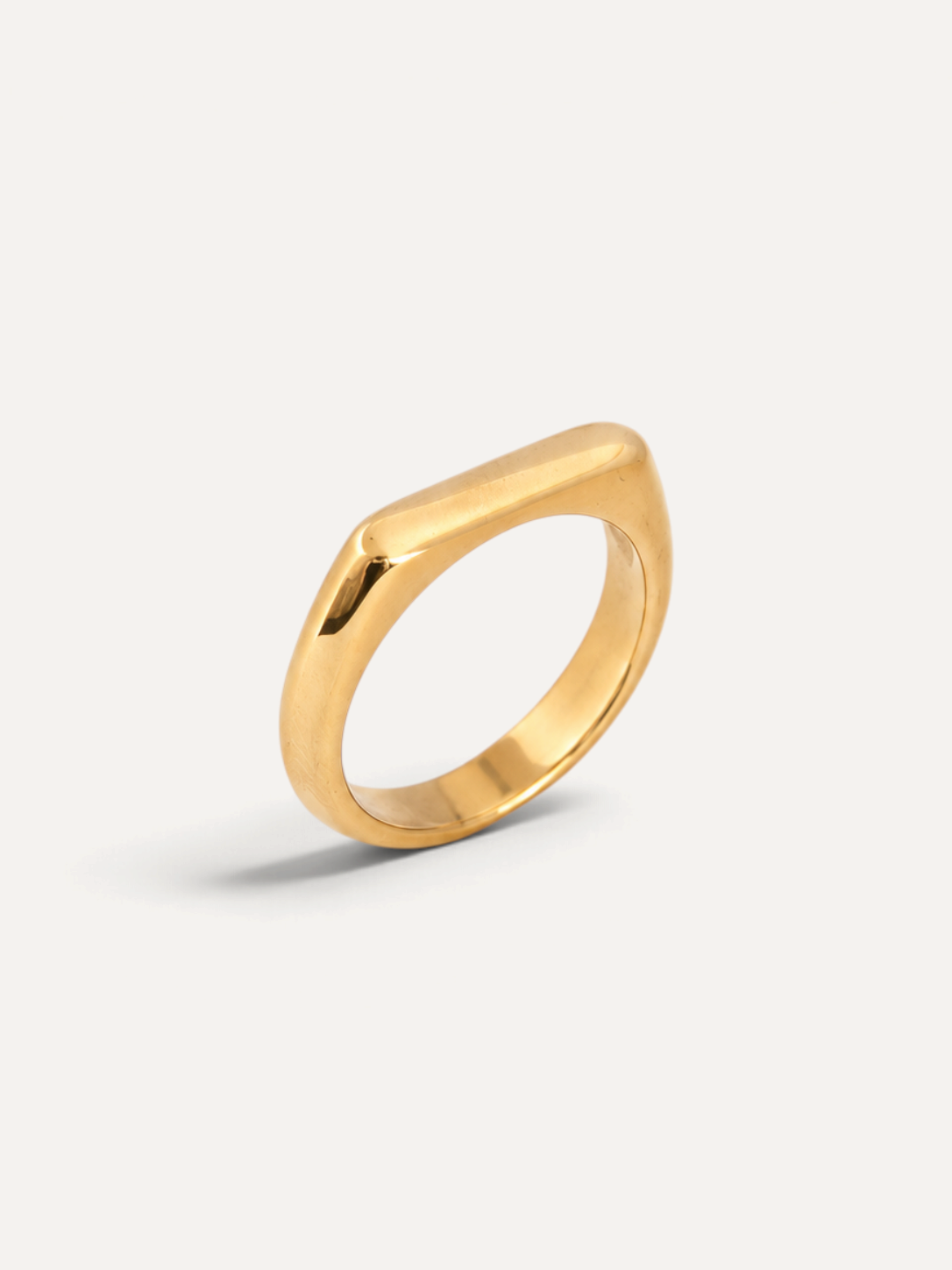 CÉLOIR Elvie Ring aus goldfarbenem Edelstahl mit minimalistischem, flachem Design auf hellem Hintergrund